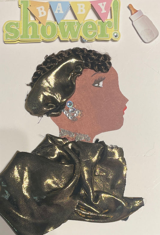 I designed this card of a woman who is wearing a golden blouse and matching hat. She also wears silver earrings and a glittery necklace. On the top of the card there is a sticker that says "Baby Shower!' and a sticker of a baby bottle.