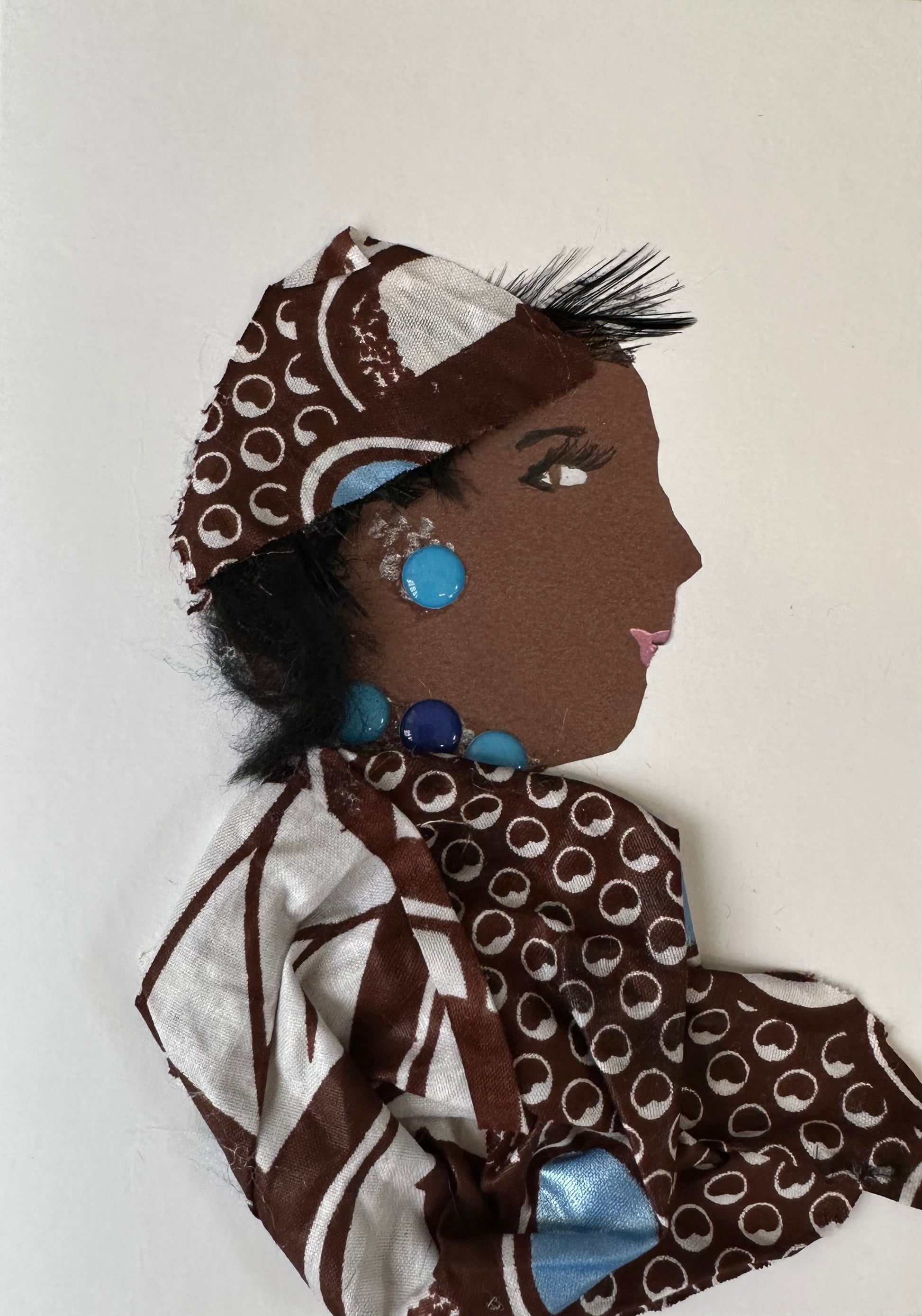 I made this handmade card of a woman draped in a matching set of brown and white Ankara material. The outfit is perfectly complete with teal gemstone jewellery.