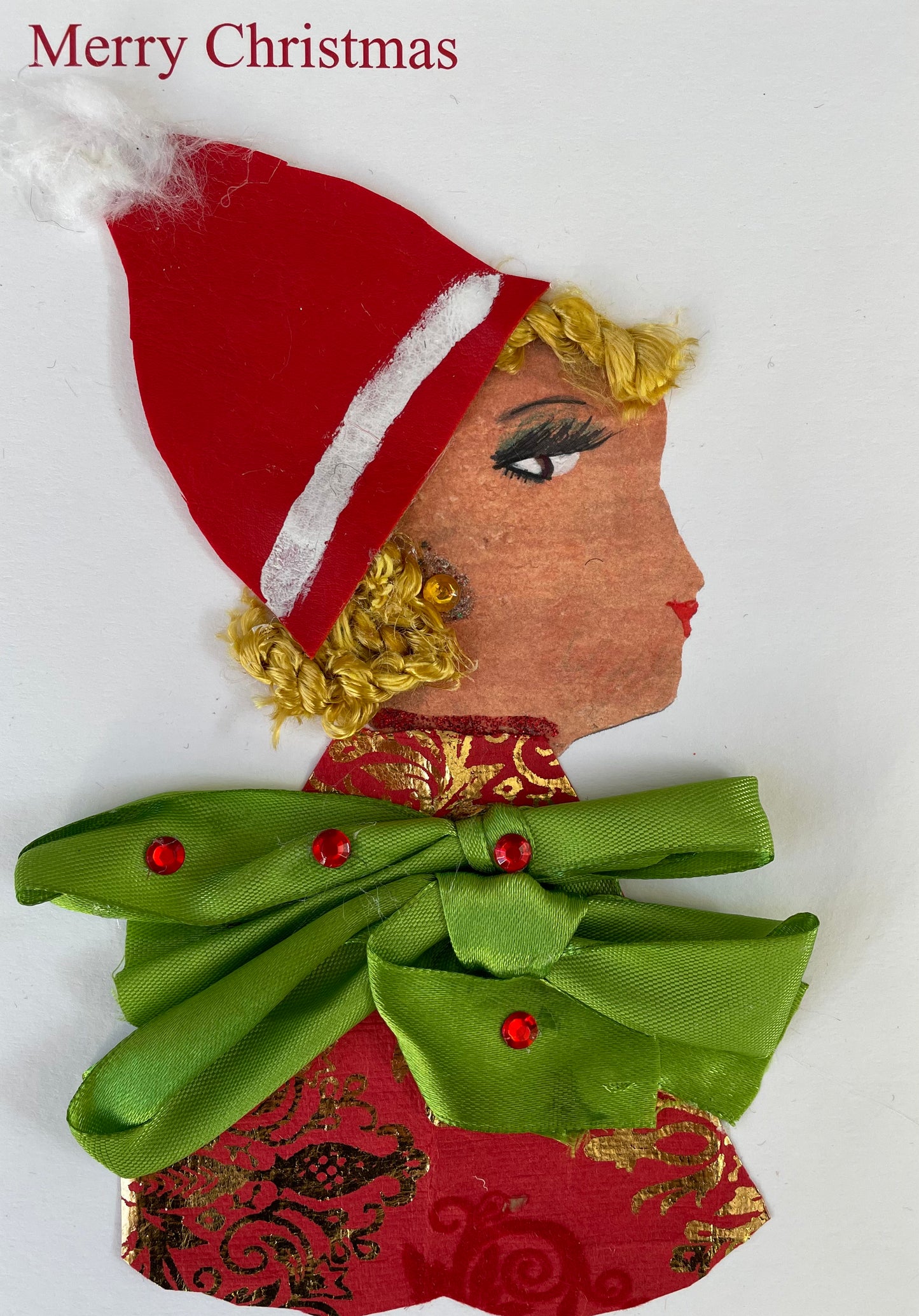 I have named this card Christmas Christina.  She is wearing a festive red and gold patterned blouse with a green bow and four red jewels on it. She wears a Santa hat on top of her blonde hair. It says "Merry Christmas" in the top left corner. How do you celebrate  Christmas in Eastcote.