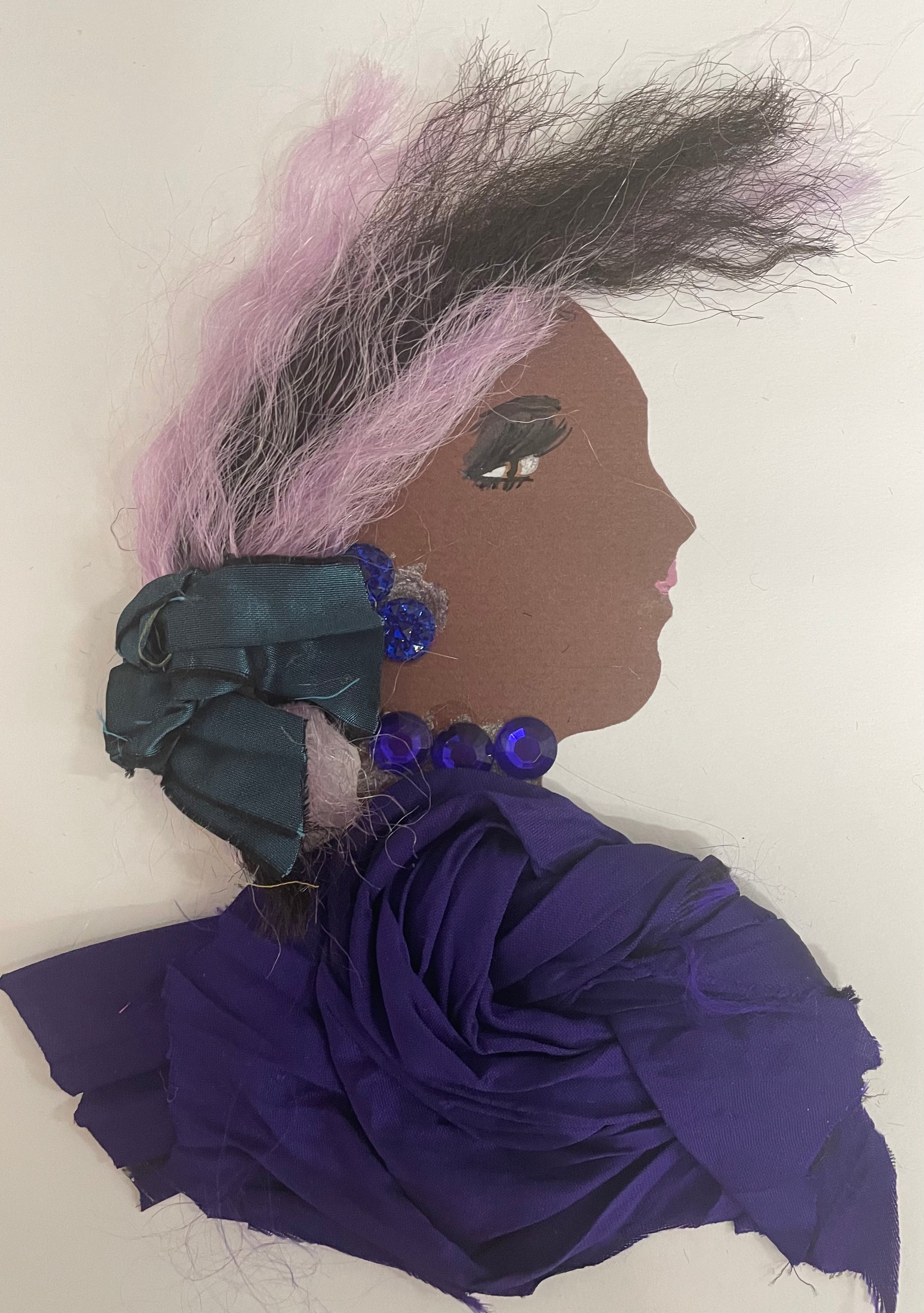 I designed this card of a woman named Peckham Purple. She is wearing a dark purple blouse. She has dark purple matching jewellery to match. There is a navy ribbon in her hair. She has light pink and black hair. 