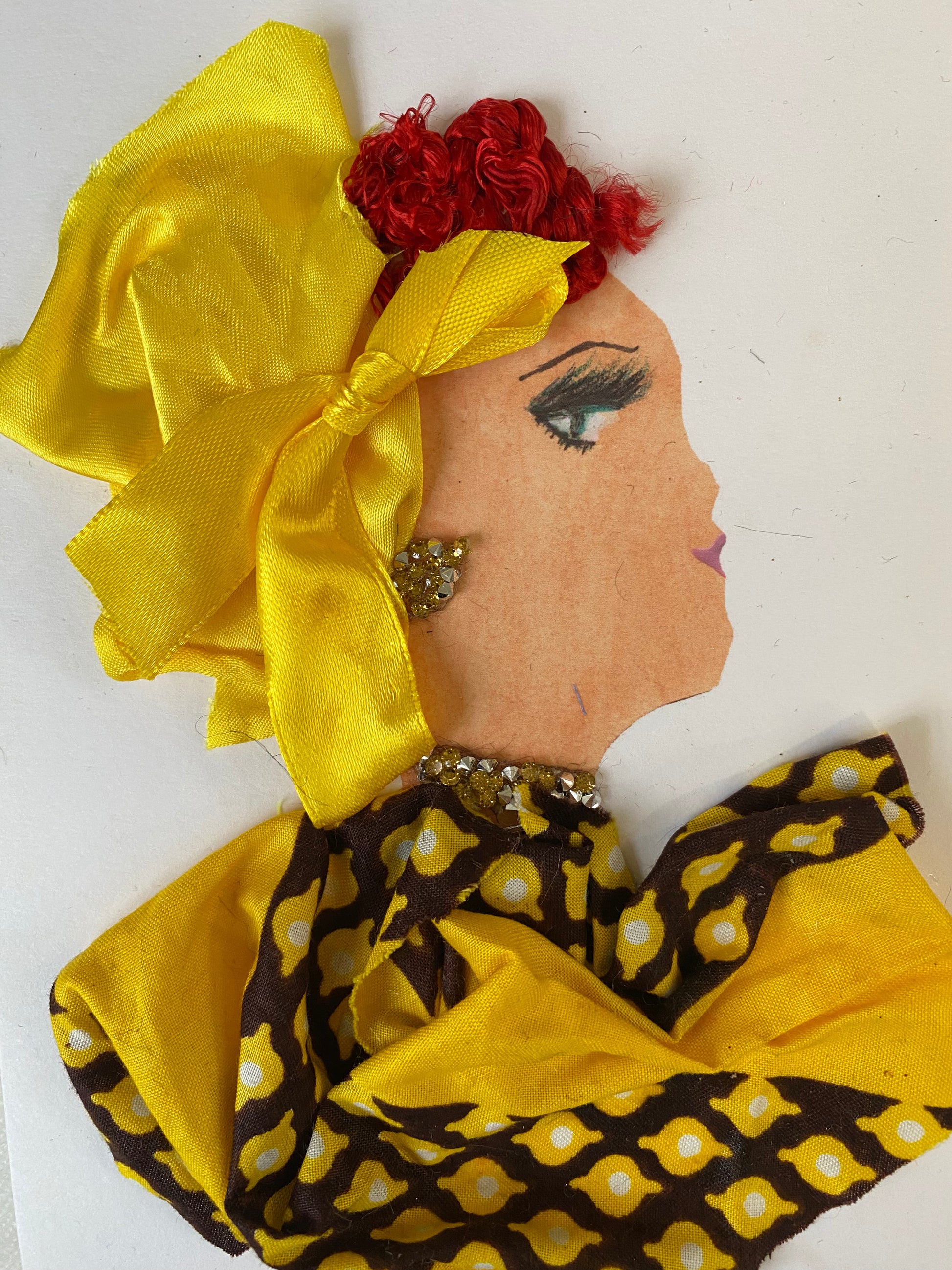 I designed this handmade card of a woman named Sunny Sydney. She has a white skin tone and is wearing a silky vibrant yellow hat that has a tie on the side. She wears a beautiful yellow and black pattern blouse. She wears dazzling yellow and silver jewellery.