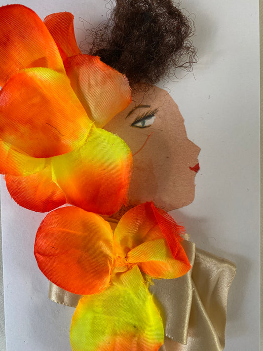 I designed this card of a woman named Maloney Orange. She has a white skin tone and is wearing an elegant floral headpiece that is yellow and orange. She wears a silky tan blouse with a floral bow that is yellow and orange. She wears sparkly jewellery. 